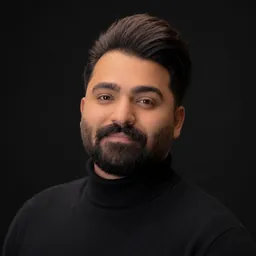 Mohammad Zafardoost, a studio portrait in a black turtleneck against a dark background.