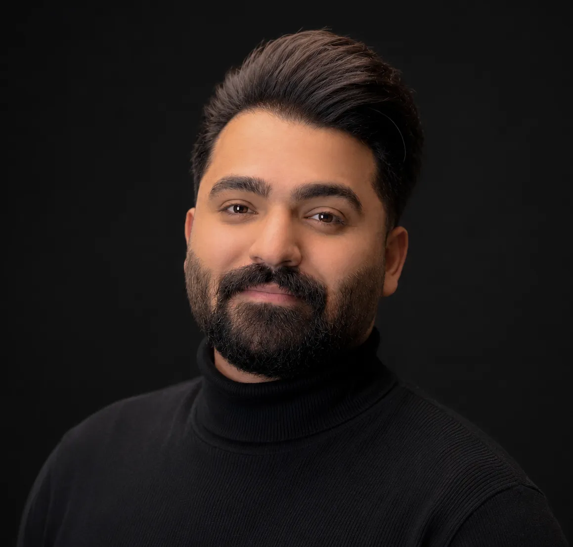 Mohammad Zafardoost, a studio portrait in a black turtleneck against a dark background.